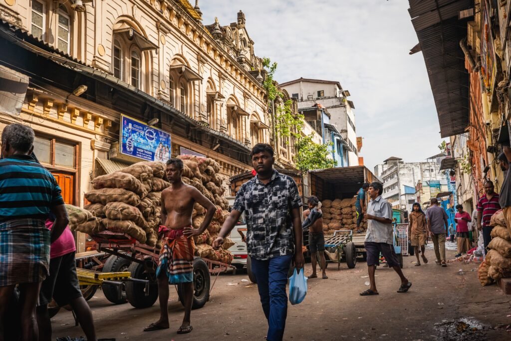 Vibrant scene of Pettah market in Colombo with people and goods in a lively street setting.